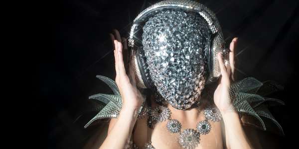 woman wearing a sparkly full face mask and headphones